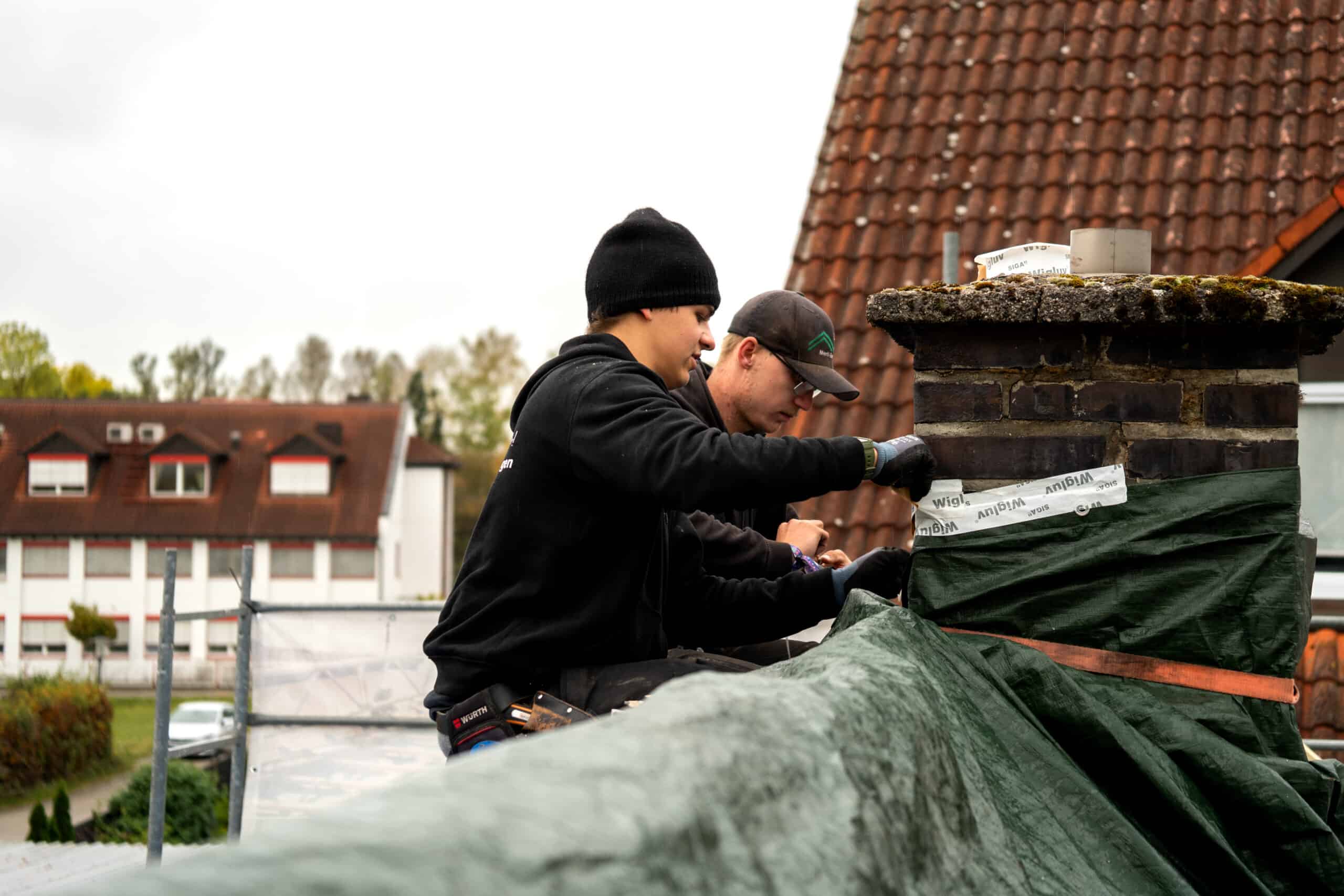 Dachdecker planen das Dach ab bevor der Regen kommt