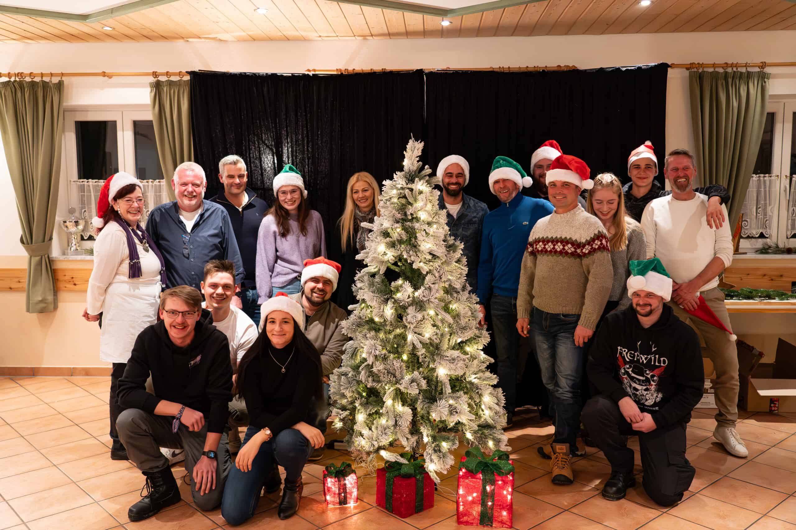 Die Dachdecker von mertl-Bedachungen stehen um einen Christbaum an der Weihnachtsfeier im Landkreis Freising